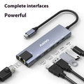 Steam Deck six-in-one aluminium docking station with HDMI, USB, and ethernet ports on a desk.