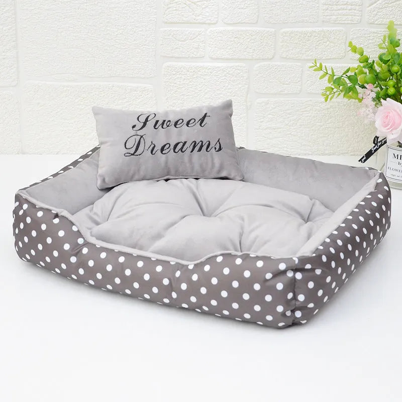 Polka dot printed cloth dog bed with matching embroidery pillow in grey, shown in a room setting.