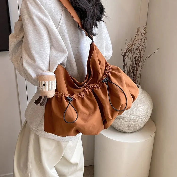 Green ultra-light pleated crossbody bag showing split pocket design and compact 35cm dimensions