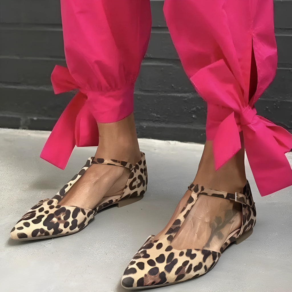 Leopard print women's pumps with pointed toe, chunky low heel, and cross shoulder straps.