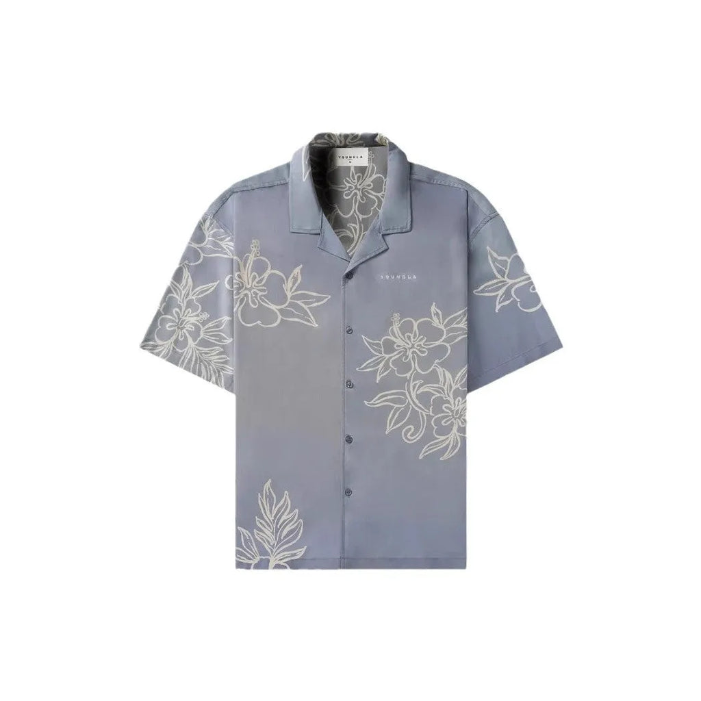 Man wearing a loose grey short-sleeve top with a floral print pattern.