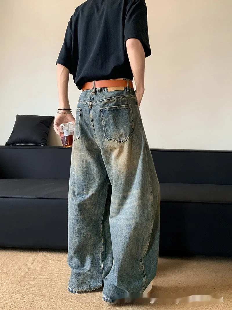 Men's retro blue distressed denim wide-leg trousers showing distressed detailing and wide-leg silhouette