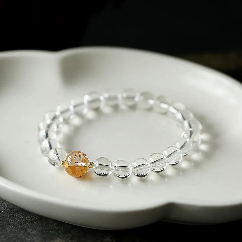Unisex geometric bracelet with black obsidian, white crystal beads, and a golden dragon bead on a wrist.