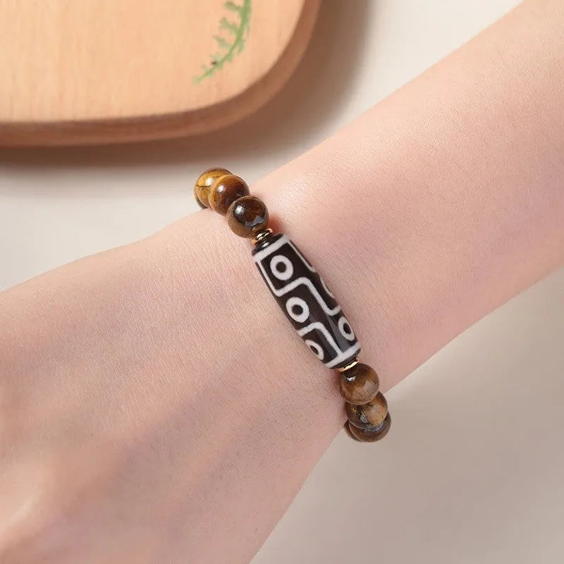 Tigereye stone bead bracelet with a single central Dzi bead featuring a circle design.