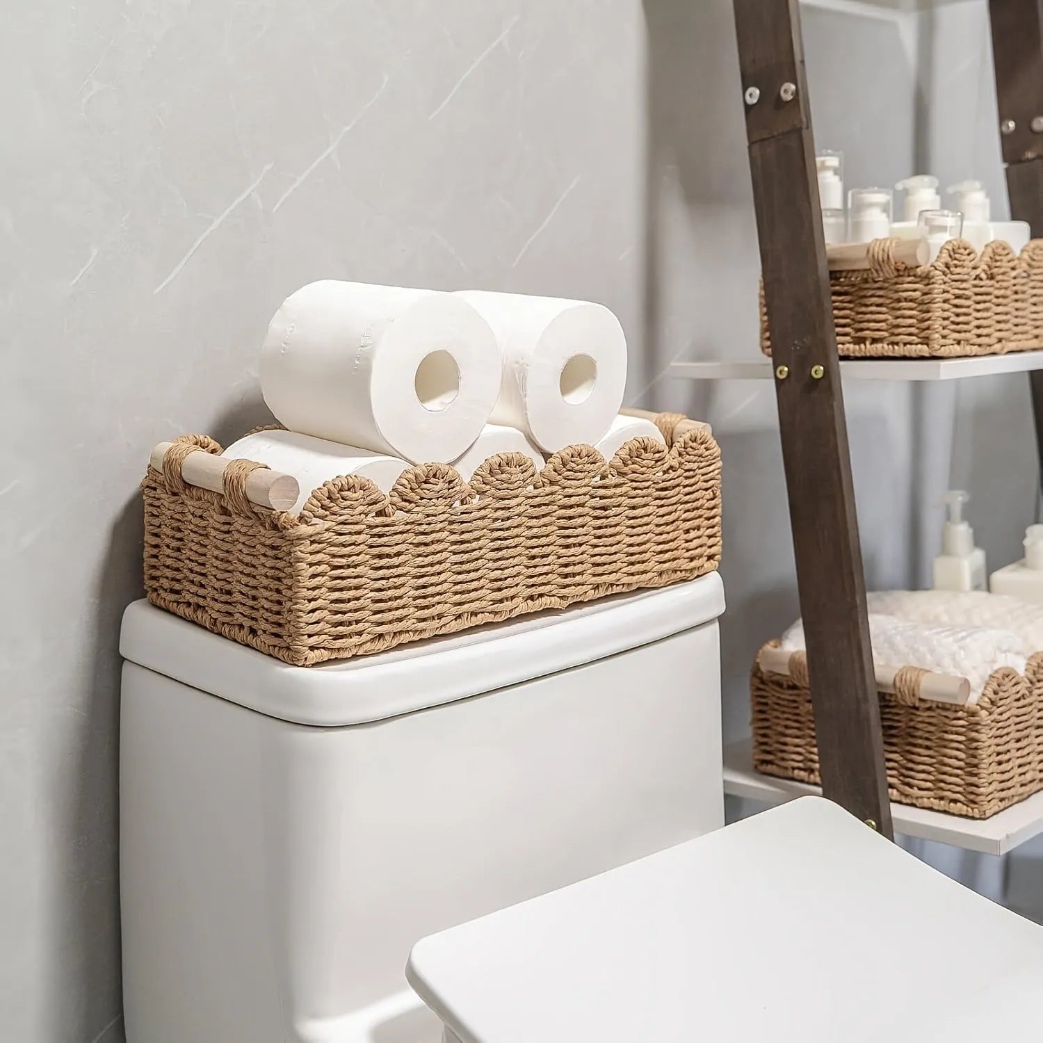 Modern simple woven paper storage basket in neutral colour on a wooden desktop holding remote controls and pens.