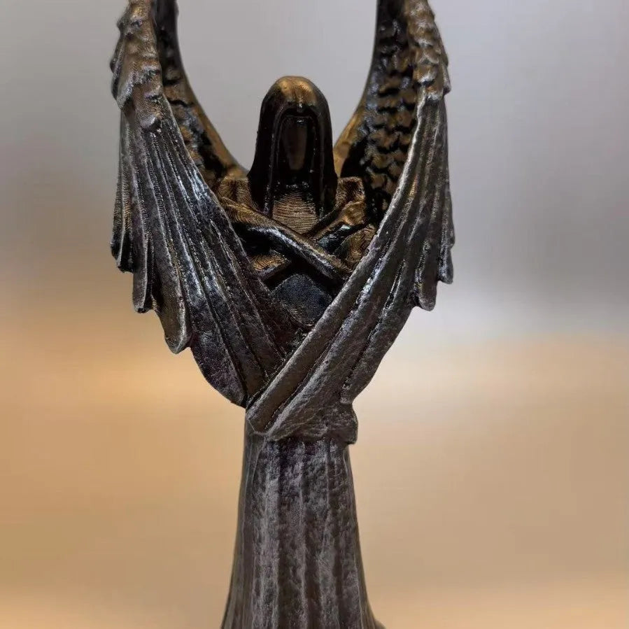 Dark coloured resin angel statue ornament with dimensions 6.5 cm by 5 cm by 17 cm.
