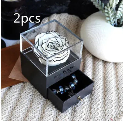 Glass eternal flower jewellery box with preserved roses and carnations inside measuring 8.5cm square