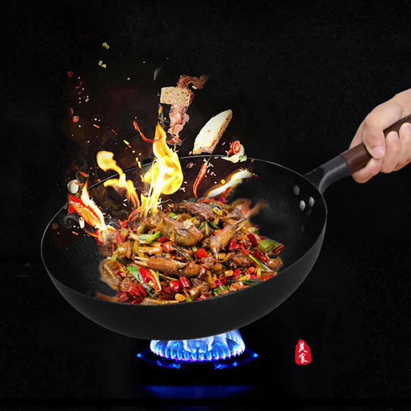 Black traditional cast iron wok pan with wooden handle and glass lid on induction hob