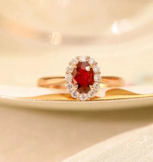 Women's silver ring with gold pigeon design and large red gemstone inlay on a floral pattern band.
