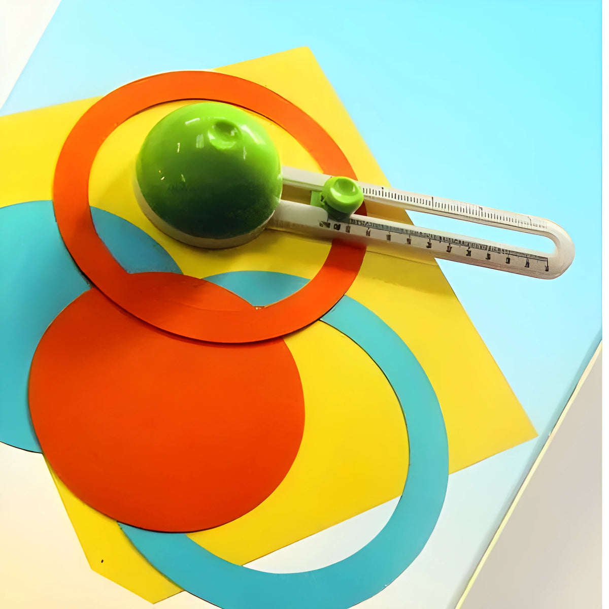 Green and orange plastic A3 round paper cutter on a colour box.