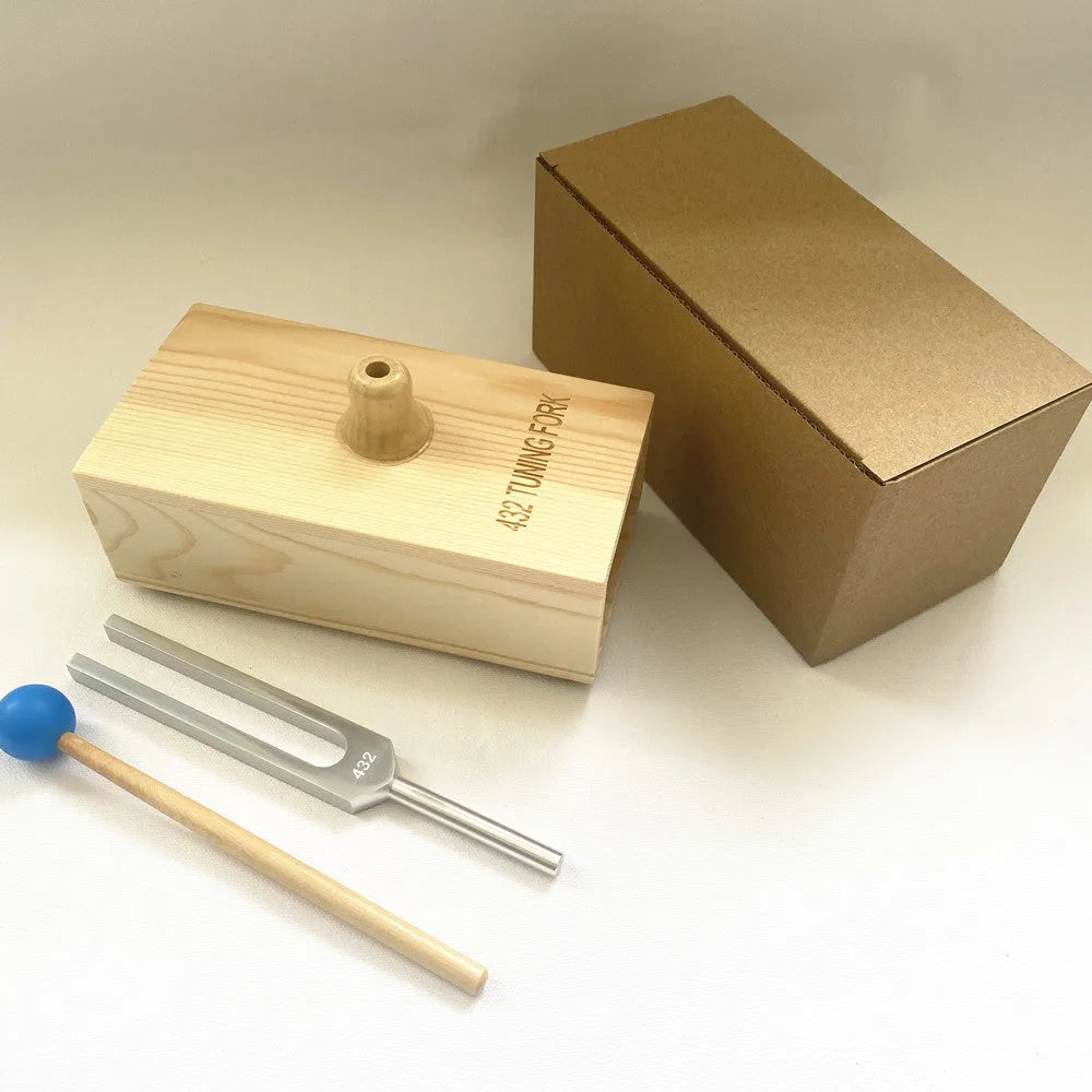 Aluminium alloy 432 Hz tuning fork with a matching speaker unit on a kraft paper box.