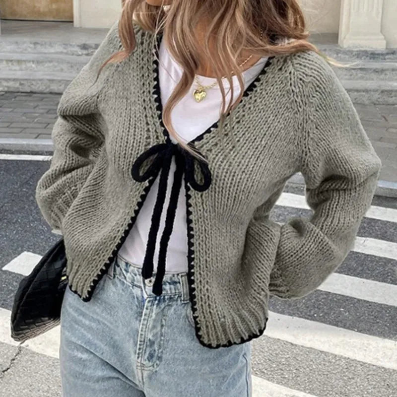 Grey lace-up front cardigan with crocheted flower detail on sleeve, shown loose and open.