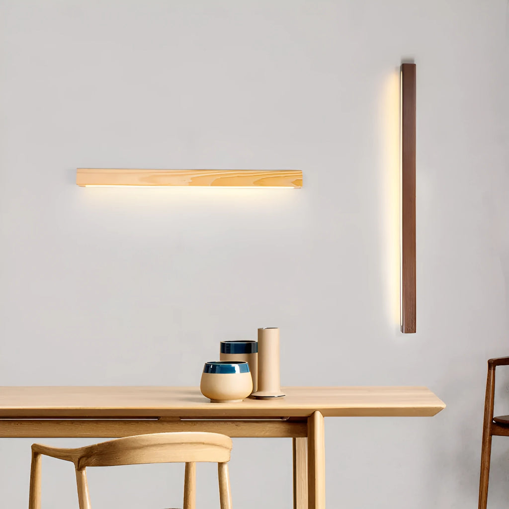 Modern walnut-colour wood log strip wall lamp with integrated LED lighting mounted on a wall.