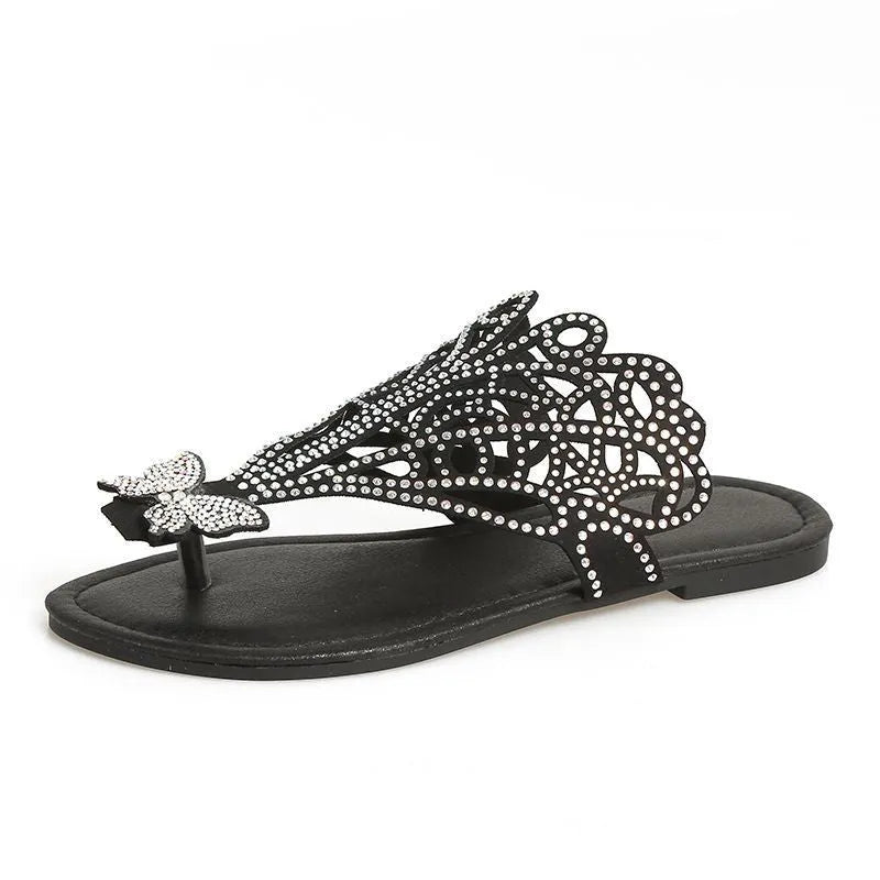 Women's black slip-on sandals with rhinestone detail and flip-toe design on a rubber sole.