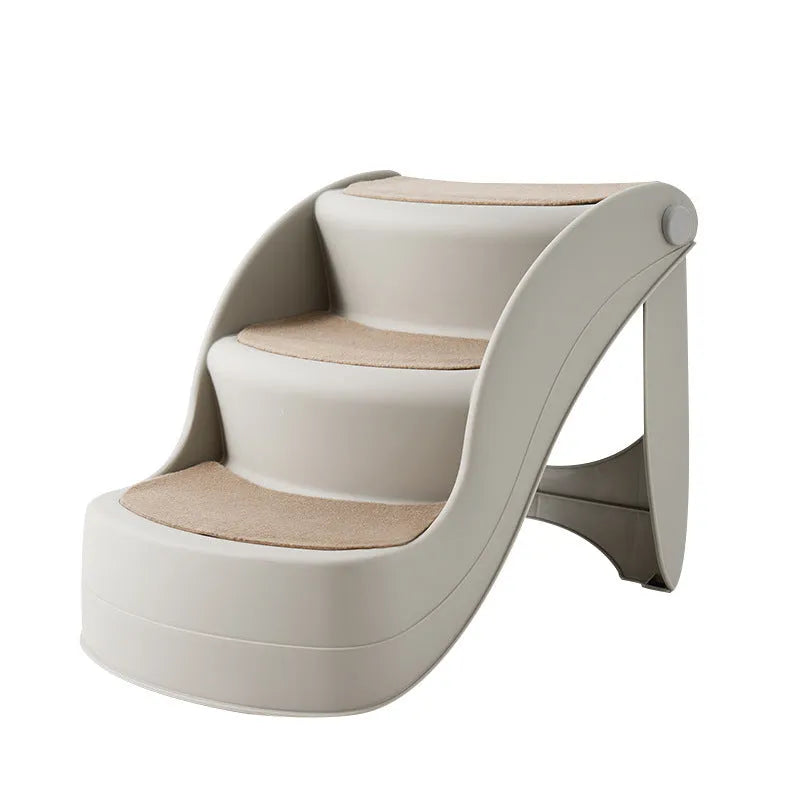 Foldable grey plastic pet stairs for small dogs and cats placed next to a sofa, showing non-slip mats on steps.