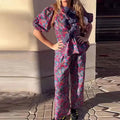 Floral print trousers suit with tie-neck top and puff sleeves, matching two-piece set