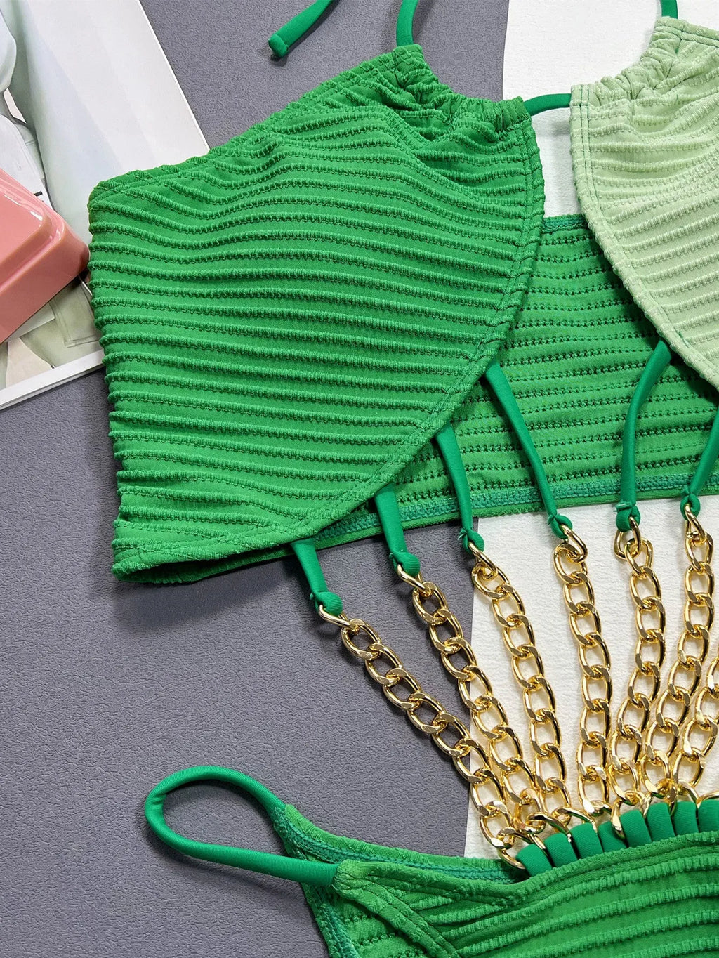 Green women's one-piece swimsuit with hollow out design on a mannequin, showing front and back views.