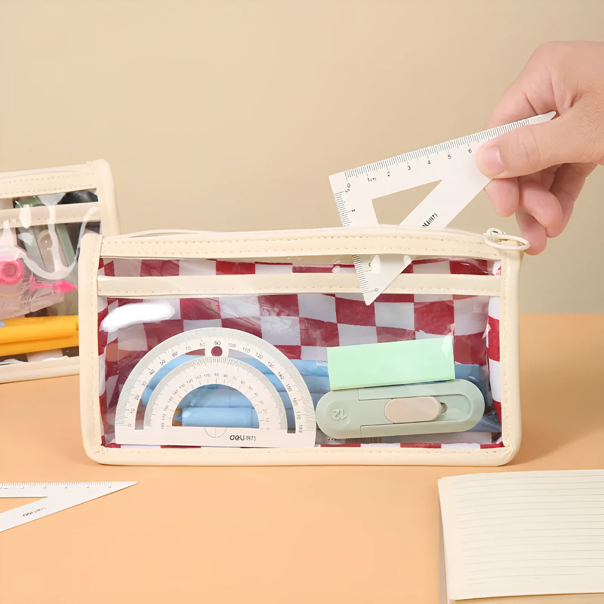 Transparent PVC pencil case with chessboard grid design showing pens inside, black and white plaid pattern