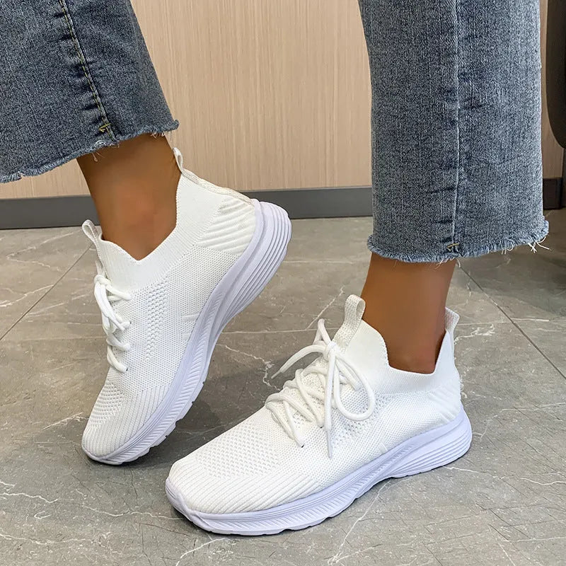Women's mesh running shoes in creamy white with Flyknit upper and rubber sole