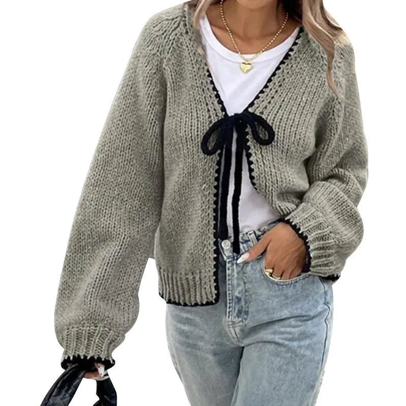 Grey lace-up front cardigan with crocheted flower detail on sleeve, shown loose and open.