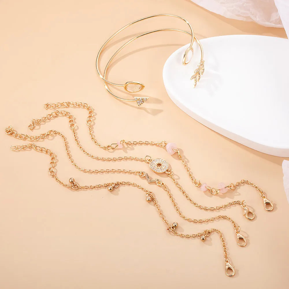 Set of six gold-coloured women's bracelets with arrow, water drop, and V-shaped pendants.