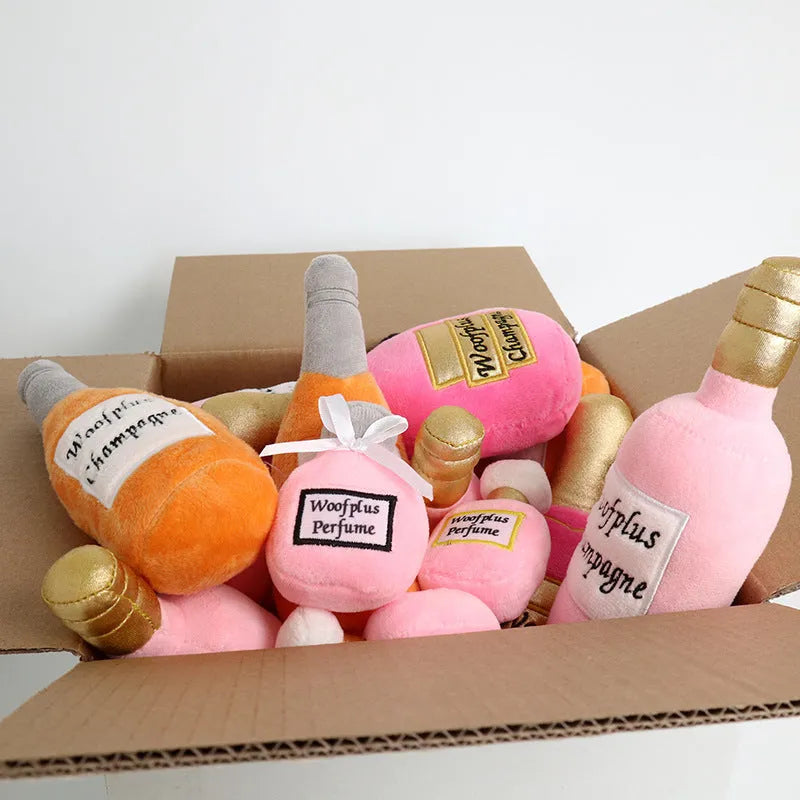 Green plush dog toy shaped like a wine bottle with a label, resting on a wooden floor.