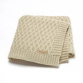 Infant hug blanket with three-dimensional lines pattern in a solid colour, measuring 70 by 90 centimetres.