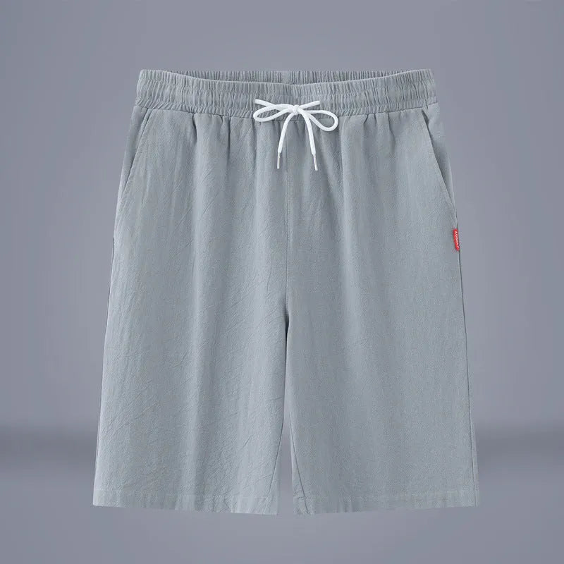 Man wearing solid colour cotton linen cropped trousers with a drawstring waist in a casual setting.
