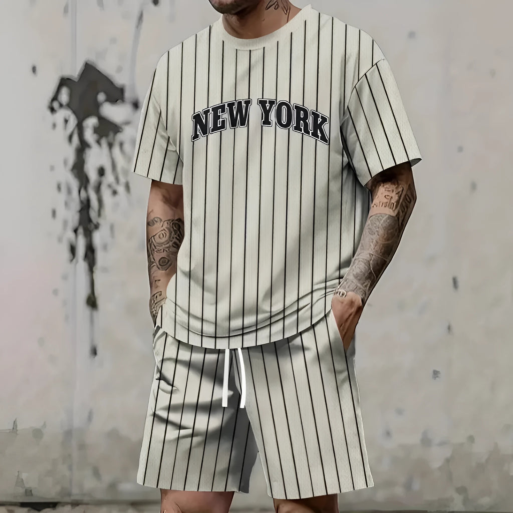 Man wearing a grey 3D printed letter design short sleeve top and matching shorts sports set.