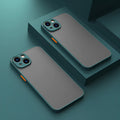 Black frosted hard iPhone case with full camera lens cover and fine hole skin-sensing design on a table.