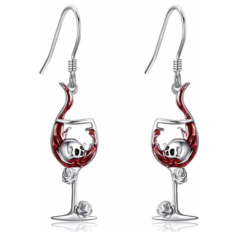 Pair of geometric drop earrings with combined skull and wine glass design in metallic finish.