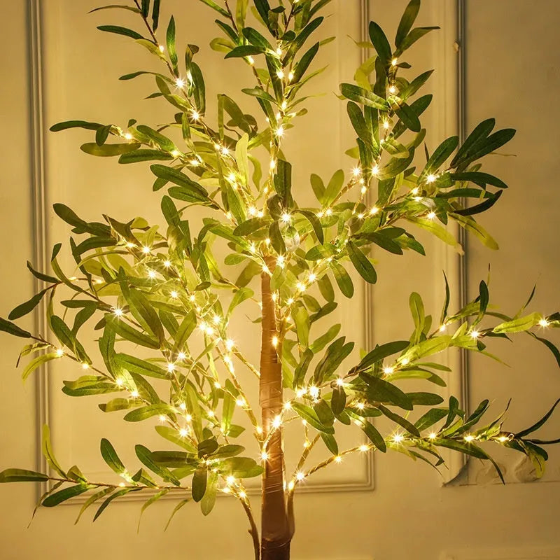 1.8 metre tall artificial olive leaf tree lamp with warm white LED lights illuminated in garden setting