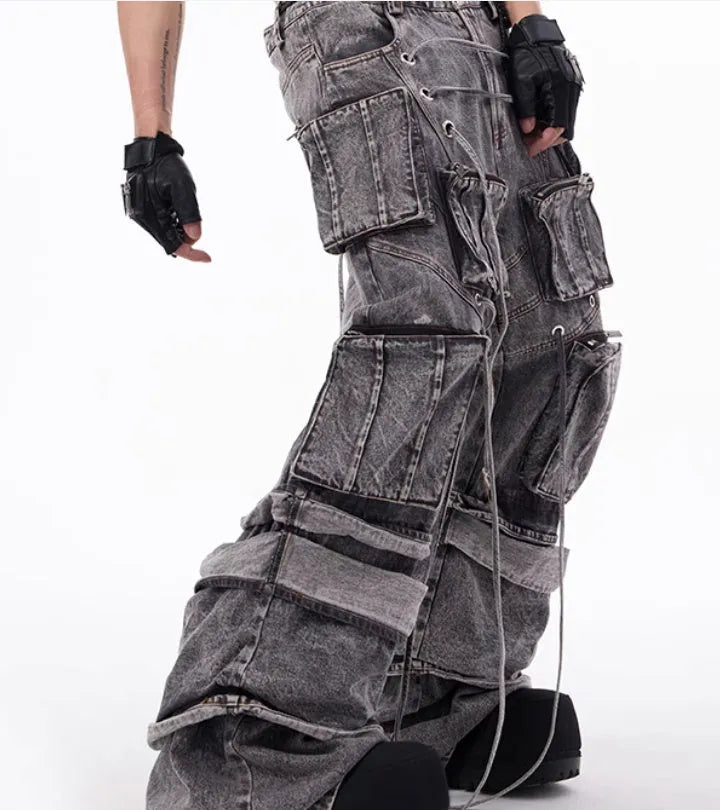 Grey distressed denim overalls with rope stitching on the legs, shown in a casual fit.