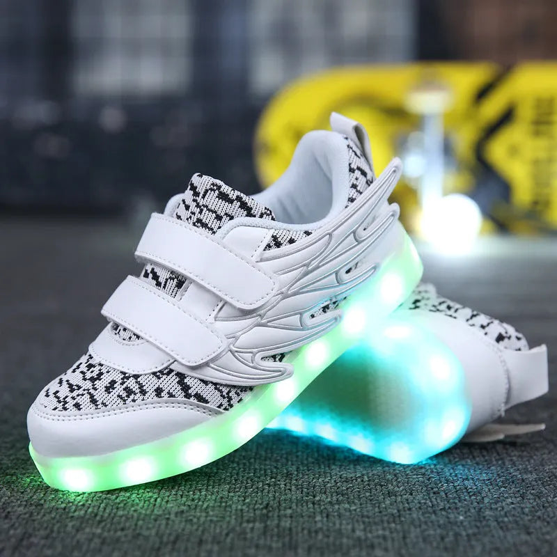 Children's plum red sneakers with colourful LED lights glowing in the soles.