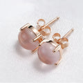 Close-up of women's drop-shaped synthetic quartz stud earrings with a rose gold finish.
