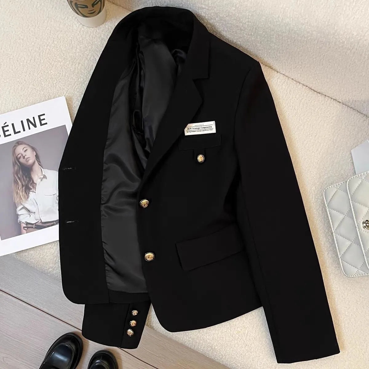 Black women's short suit coat with pockets, loose fit, and regular long sleeves.