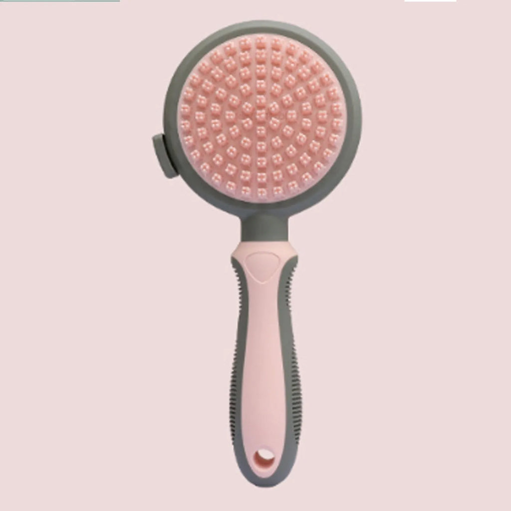 Pink and green double-sided cat brush with release button next to a flea comb.