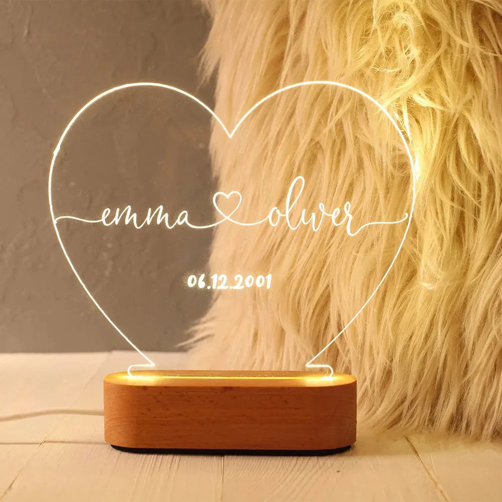 Personalised acrylic night light showing illuminated custom names and date on a transparent panel.