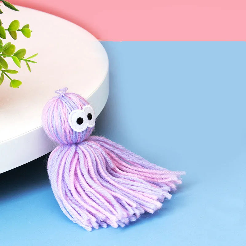 Set of four hanging wool ball cat toys with plastic teaser sticks in blue grey, pink and blue, and pink purple colours