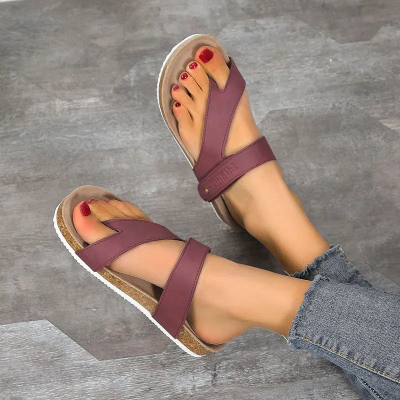 Flat toe ring flip-flops in blue with a thick foam sole on a wooden floor.