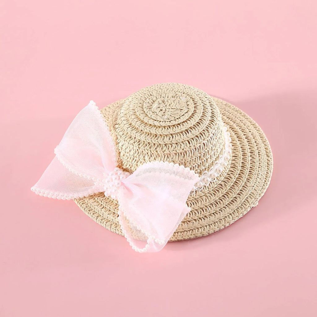 Pet cat wearing a woven Lafite leaf straw hat with a pearl butterfly decoration.