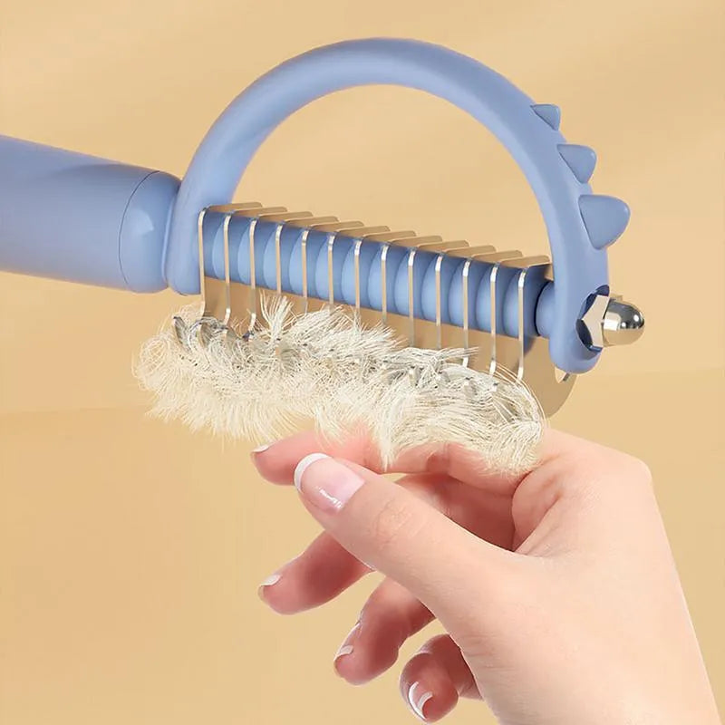 Blue dinosaur-shaped self-cleaning cat brush with stainless steel pins