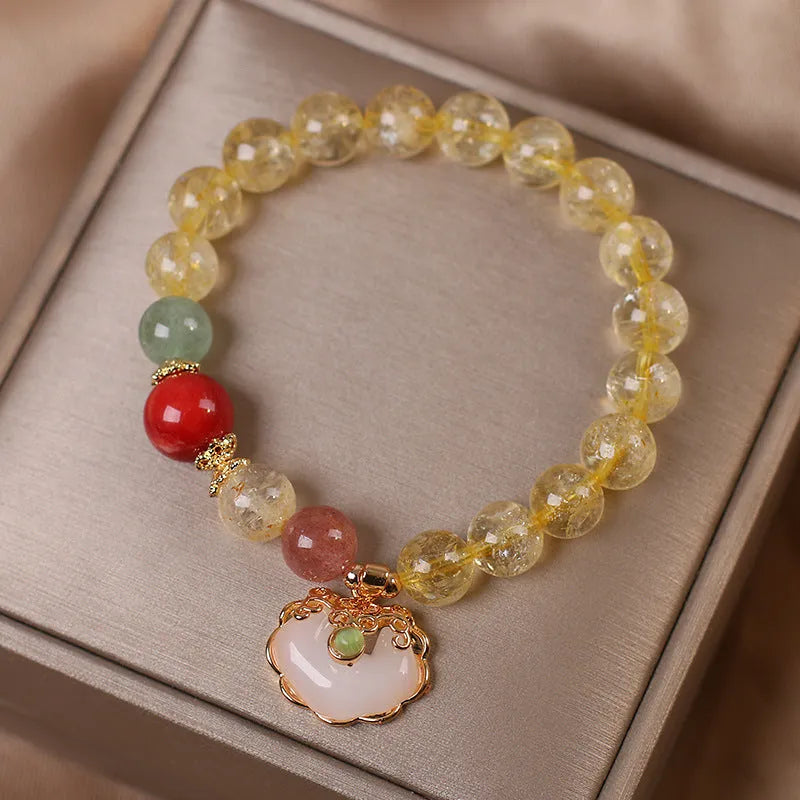 Women's yellow alloy bracelet with a ruyi pendant charm holding natural citrine and yellow hair crystal jade.