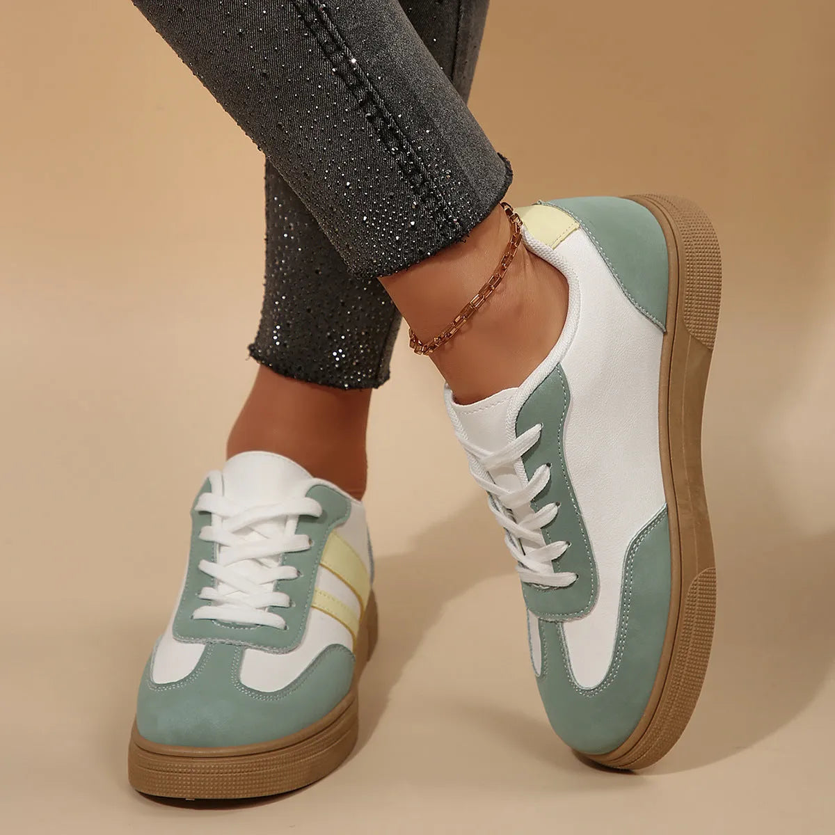 Green women's retro sports pumps with cross straps and leather stitching details