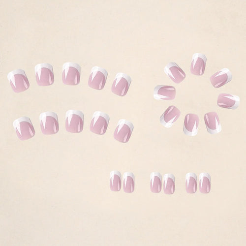 24 white false nail tips with a black and white plaid pattern, arranged on a card.