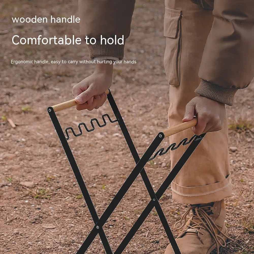Black foldable outdoor iron trash rack with wooden handle holding a white bin bag.