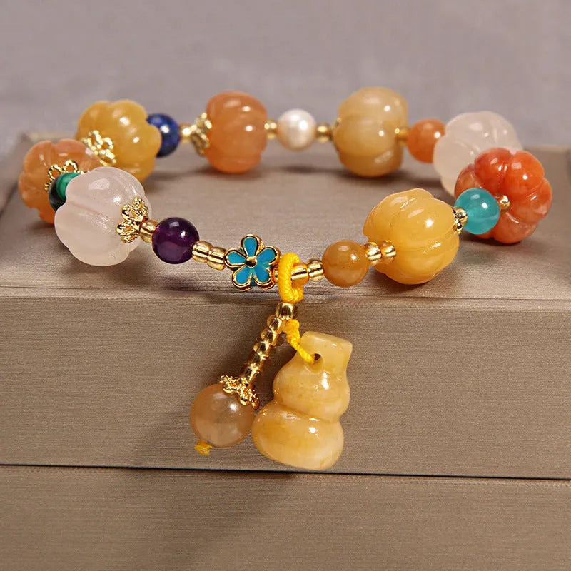 Adjustable khaki bracelet with large yellow agate bead on gold silk cord.