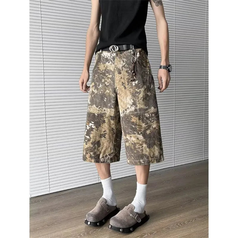 Men's yellow denim jeans with a snake pattern and camouflage tooling print, showing cropped leg length.