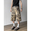 Men's yellow denim jeans with a snake pattern and camouflage tooling print, showing cropped leg length.