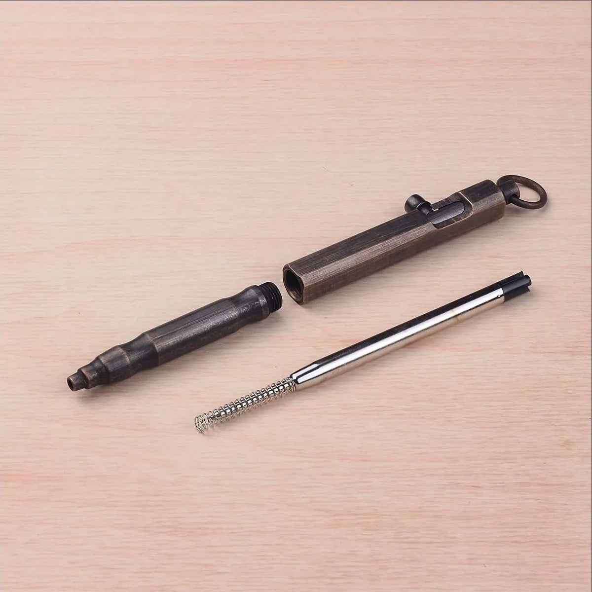 Brass hexagonal bolt tactical pen with machine gun design in natural brass or vintage black finish.